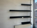 a radiator in front of a window with shelves on the wall
