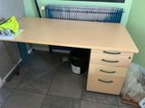 a wooden desk with drawers and a radiator in the corner
