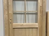 two wooden doors with glass panes in front of a white wall