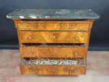 an old wooden chest of drawers with a marble top