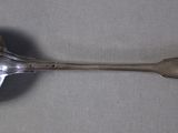 a silver spoon with a spoon handle on a table