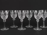a set of six crystal wine glasses on a black background