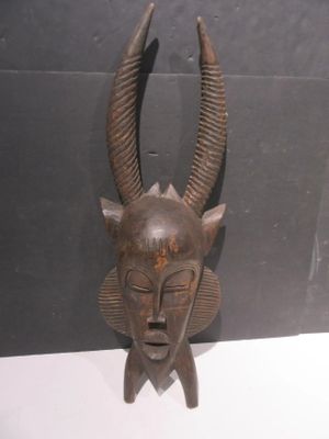 an image of a wooden mask hanging on a wall