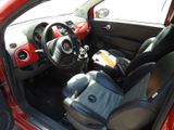 the interior of a small red car with black seats and a steering wheel