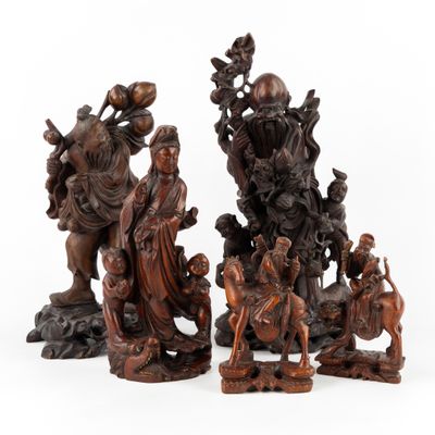 un ensemble de quatre figurines en bois sculpté représentant des personnages et des animaux