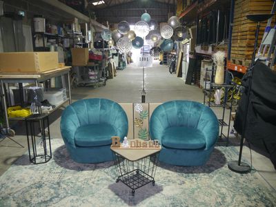 two blue chairs and a table in the middle of a room