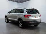 the rear end of a silver suv parked in a white room