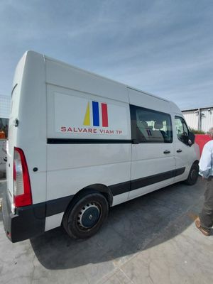 un homme debout à côté d'une camionnette blanche sur un parking