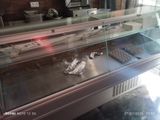 a glass display case with donuts and other pastries in it