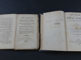 an old book opened on top of a table on a black surface