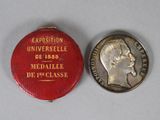 une image représentant une médaille et une pièce de monnaie sur un fond blanc