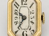 une image d'une montre en or avec des chiffres romains sur le cadran