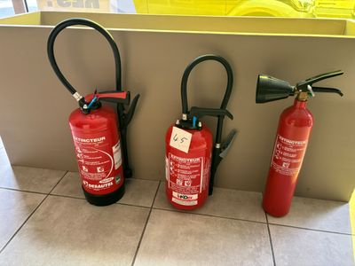 three fire extinguisors sitting on the floor next to each other
