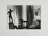 une vieille photo en noir et blanc d'une femme debout devant une fenêtre