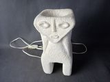 a white ceramic sculpture of a man with a face on it