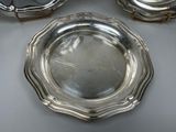 three silver plates sitting on a table next to each other