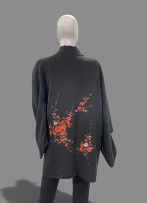 an image of a mannequin dressed in a black suit with red flowers on it
