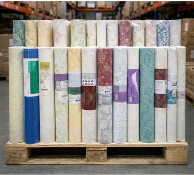 de nombreux rouleaux de tissu sur une palette dans un entrepôt