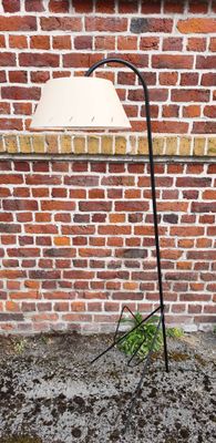 un lampadaire fixé à un poteau devant un mur de briques