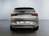 the rear end of a silver car in a white room