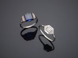 two rings and a ring with a blue stone on a black surface