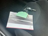 une photo d'un siège auto sur lequel sont posés une clé de voiture et une carte