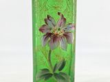 a green vase with a purple flower on it