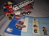 a lego fire truck and a book on a bed
