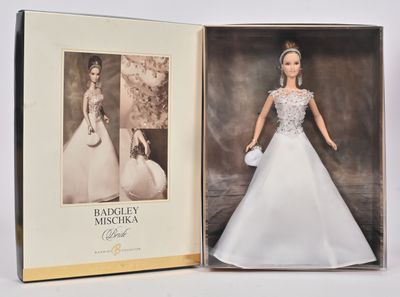 une image représentant une poupée Barbie dans une boîte, sur laquelle figure la photo d'une femme en robe de mariée
