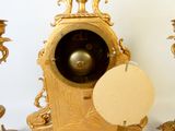 une horloge dorée sur laquelle est posée une étiquette en papier