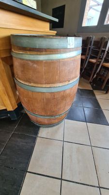 a large wooden barrel sitting on the floor in a restaurant