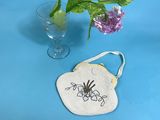 a small bag with a spider on it next to a vase