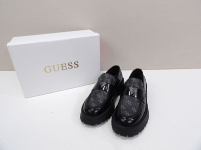 a pair of black shoes sitting on top of a white table