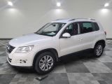 the white volkswagen suv is parked on a checkered tile floor