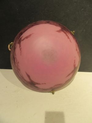 a pink glass ball sitting on top of a white table