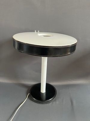 une photo d'une lampe de table en noir et blanc avec un pied blanc