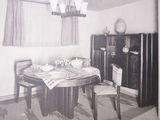a black and white photo of a dining room with a table and chairs