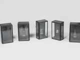 quatre lampes en verre noir sont alignées sur une surface blanche