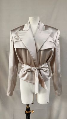 une photo d'un mannequin portant une veste blanche et un nœud papillon