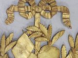 a gold plate with flowers and leaves on it
