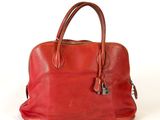 une image représentant un sac à main en cuir rouge sur fond blanc