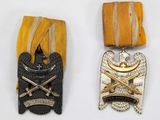 two medals are shown next to each other on a white surface