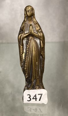 statue d'une femme tenant un bébé dans ses bras, posée sur une table en verre