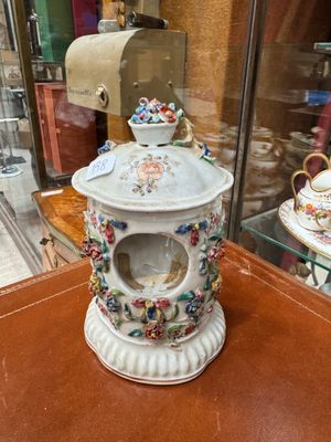 a tea pot and a cup on display in a glass case