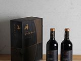 two bottles of wine sitting on a table next to a box