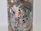 an image of a vase with a picture of people in a garden