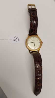 gros plan d'une montre-bracelet sur une surface blanche