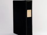 an image of a black binder with a gold button on it
