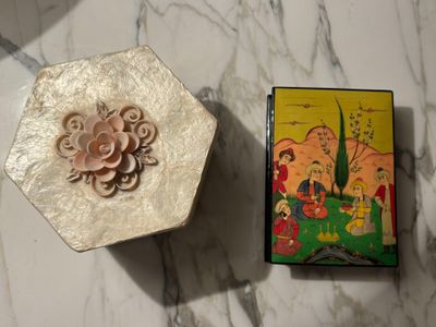 a small box with a flower on it next to a small box with a flower on it