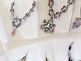several different types of jewelry are displayed on a white surface